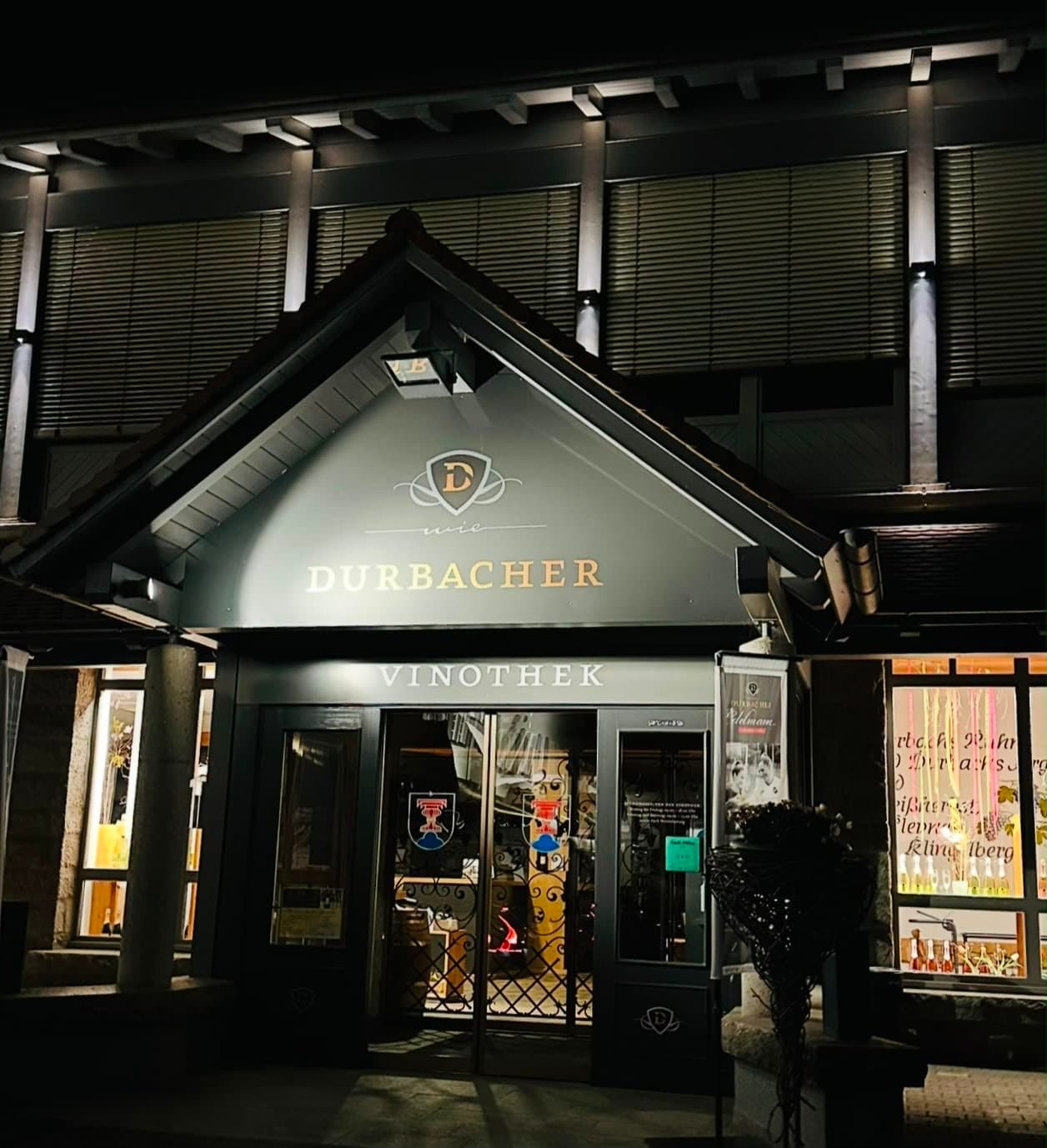 Beleuchteter Eingang der Vinothek der Durbacher Winzer bei Nacht