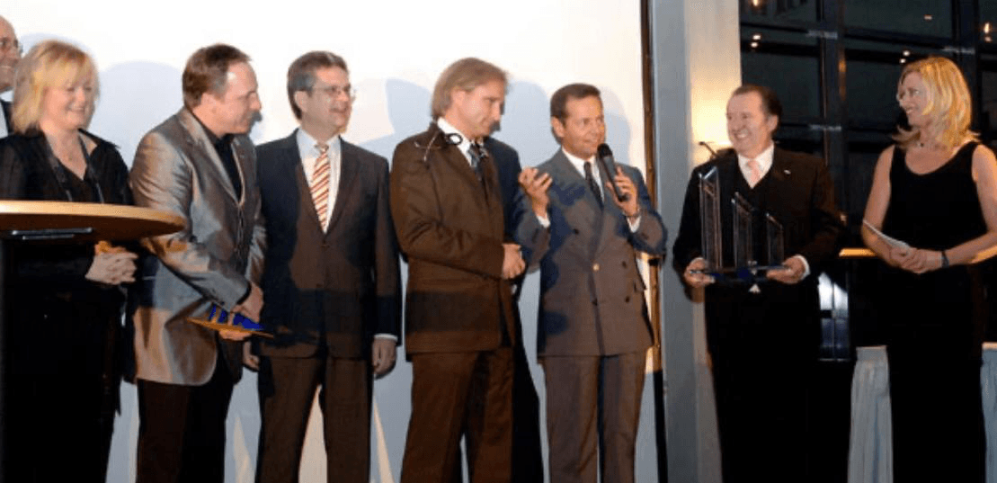 Patric P. Kutscher bei einer Preisverleihung mit Trophäe